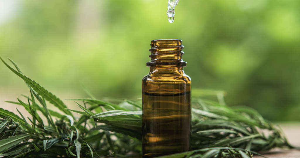 Fibromyalgia: A small bottle of oil on a surface surrounded by cannabis leaves