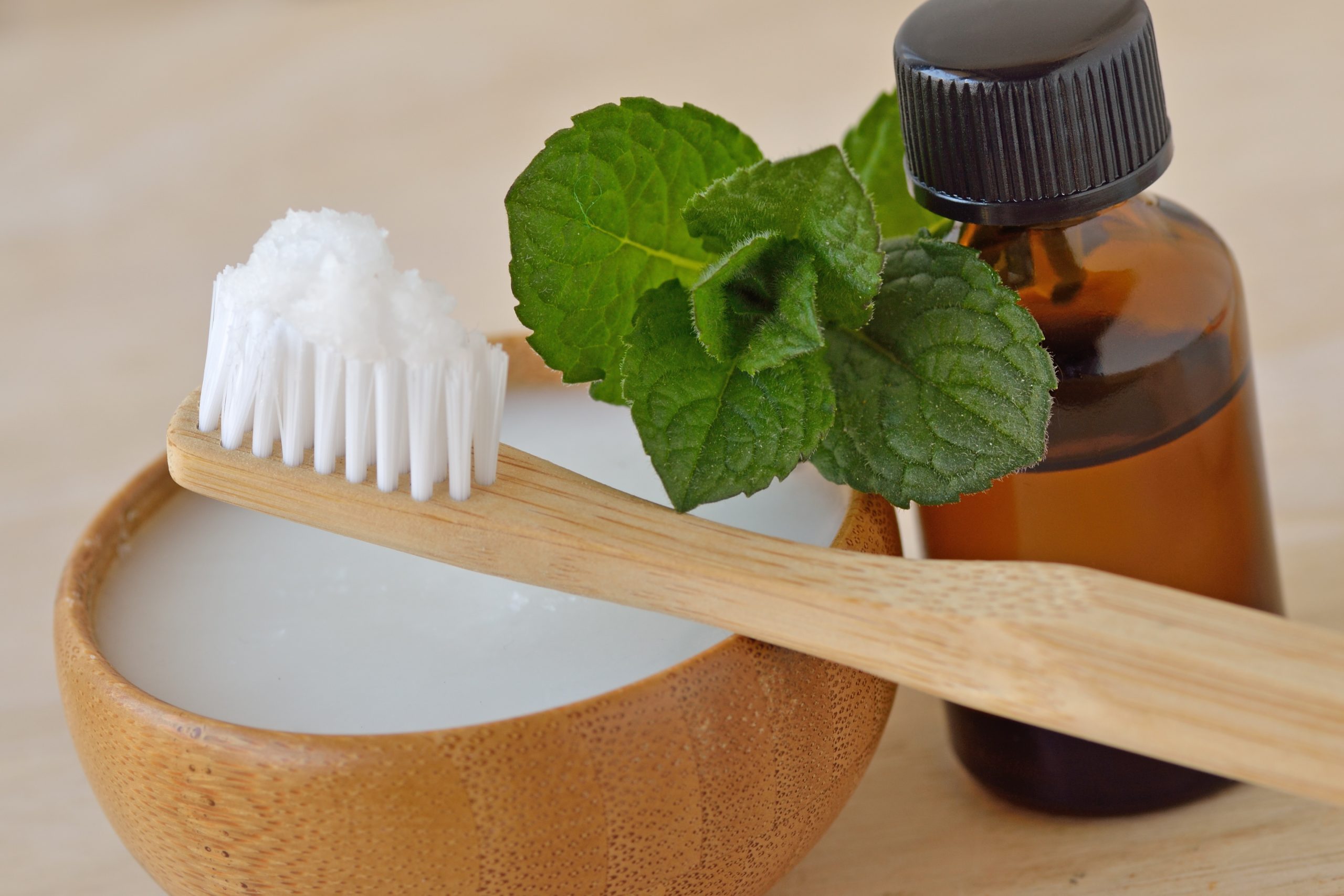 CBD: A wooden toothbrush with a sprig of mint and a small bottle of CBD