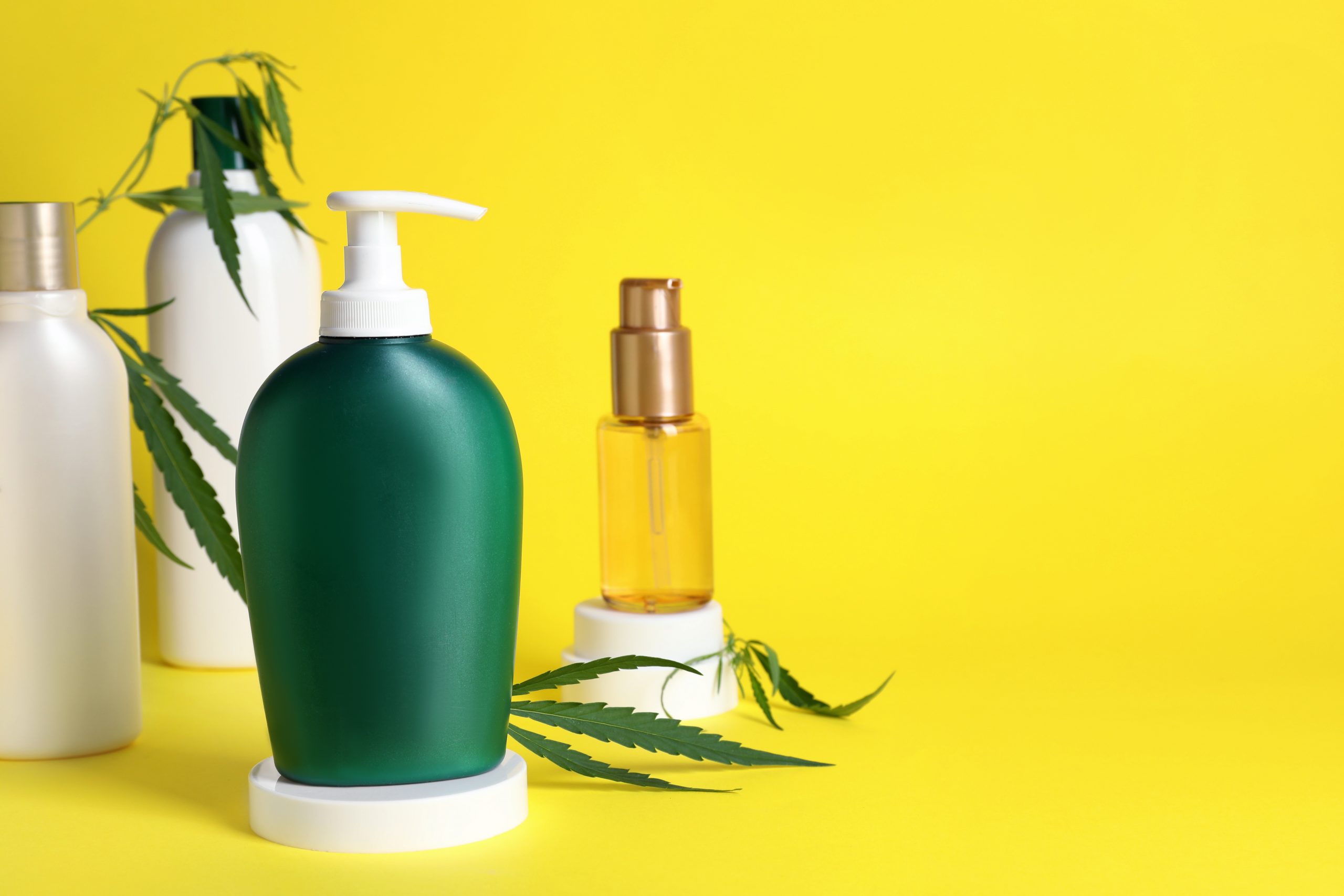 CBD shampoo: A collection of bottles containing CBD against a yellow background. 