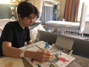 Louis in a hospital bed painting while undergoing treatment for seizures